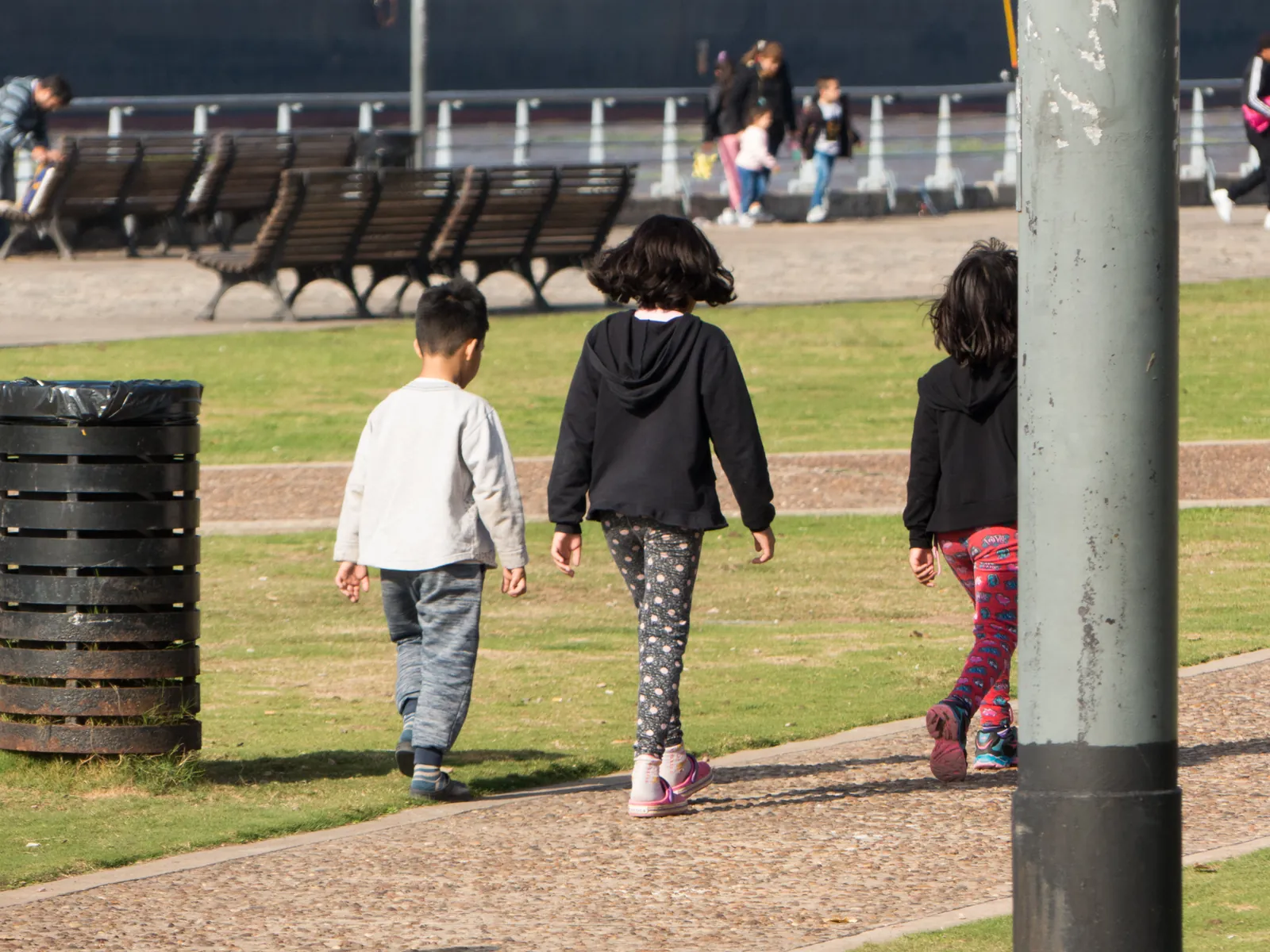 Surveillant traverse la cour avec un groupe d'enfants après le repas
