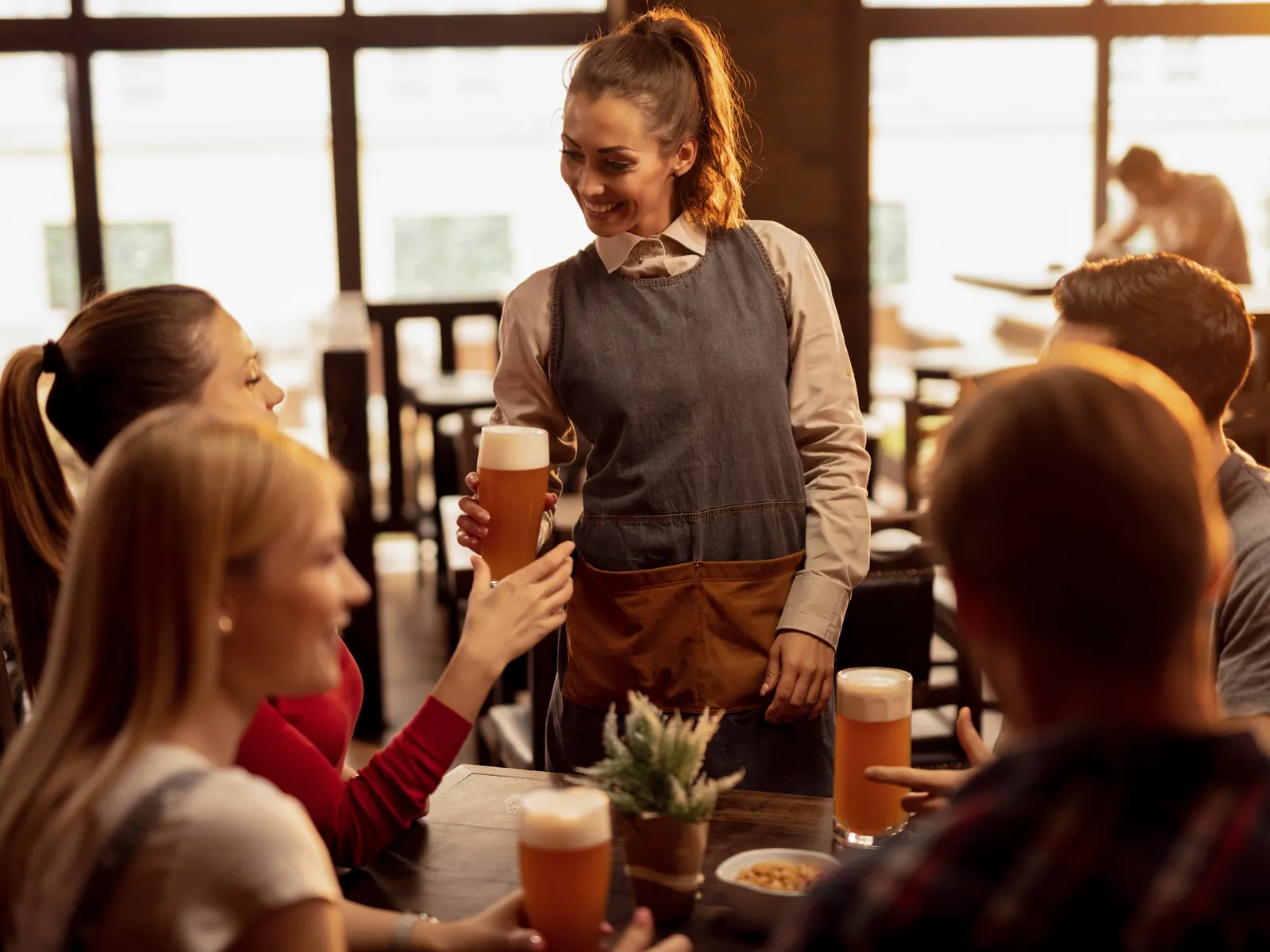 Étudiante qui sert des clients en terrasse un vendredi soir