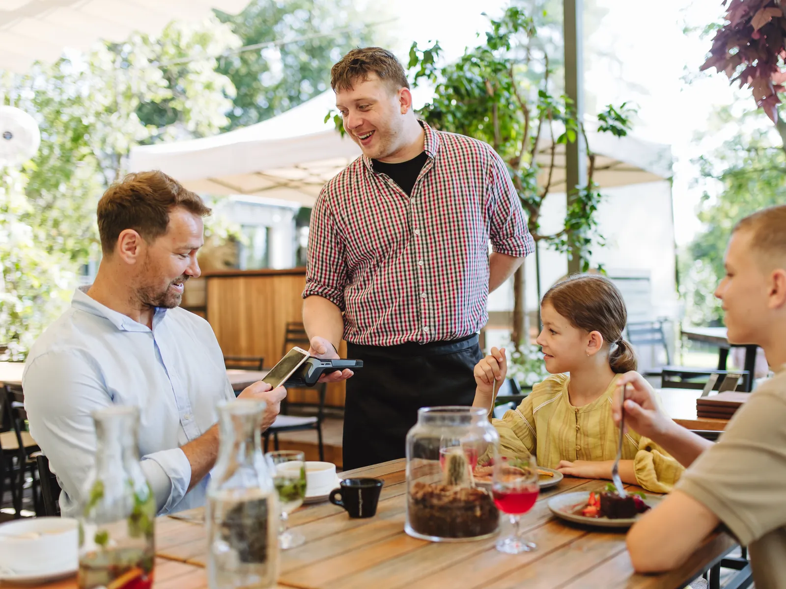 Serveur qui apporte un brunch du dimanche à une famille