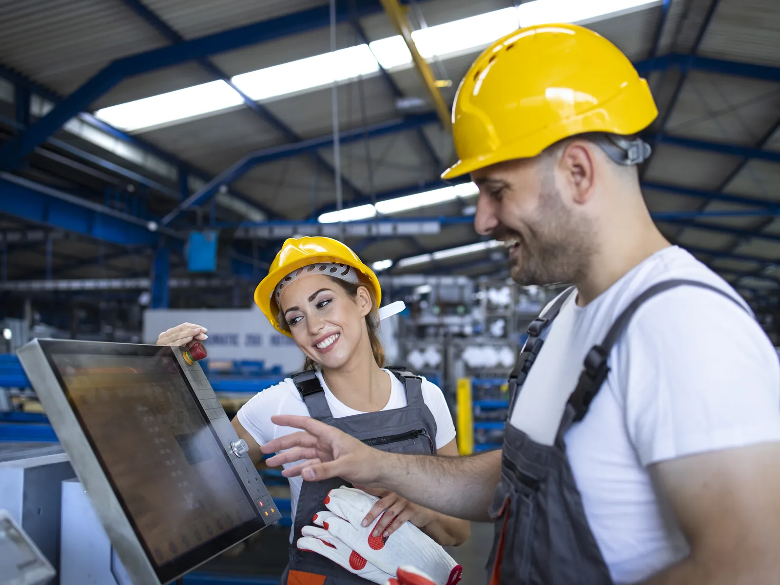 Collègue expérimenté expliquant la machine à un nouveau travailleur
