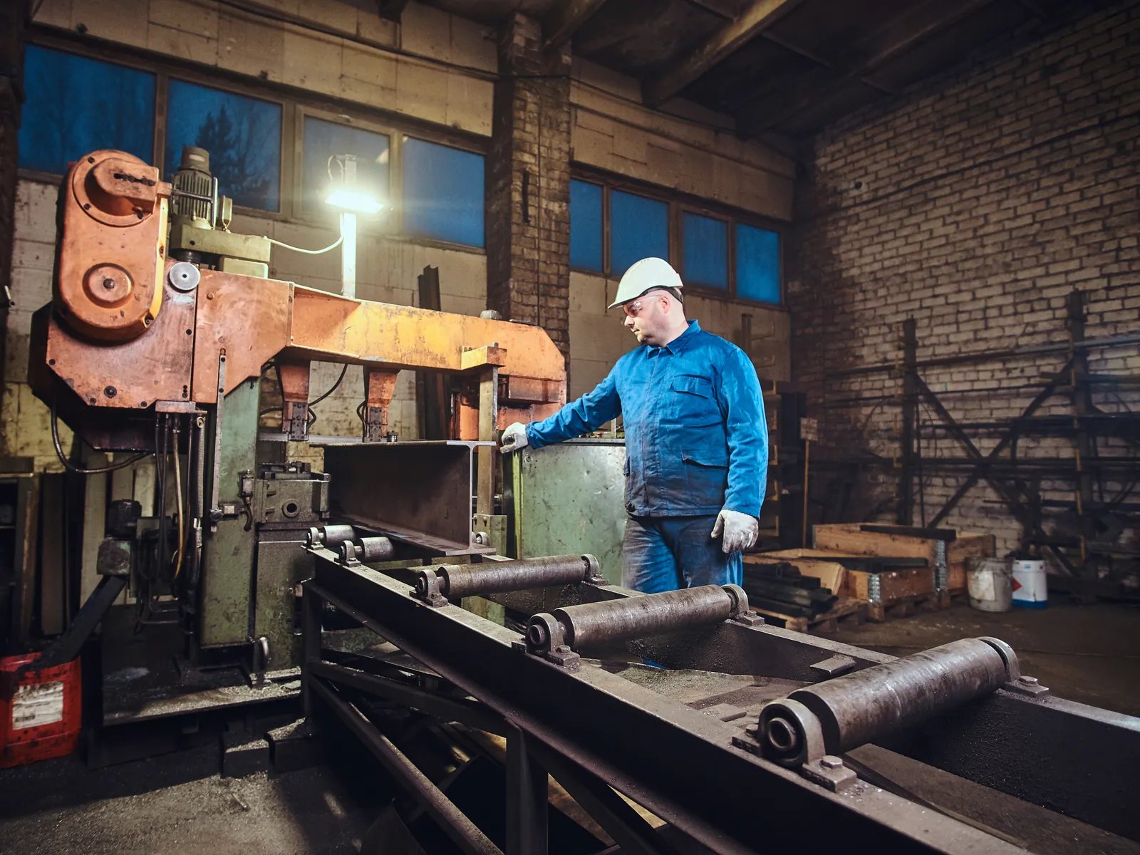 Ouvrier à une machine dans un grand hall de production