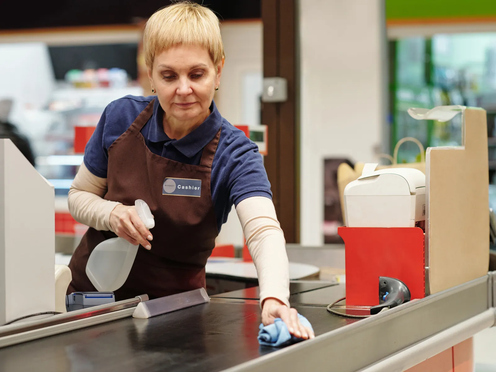 Caissière scanne les courses d'un client à une caisse de supermarché