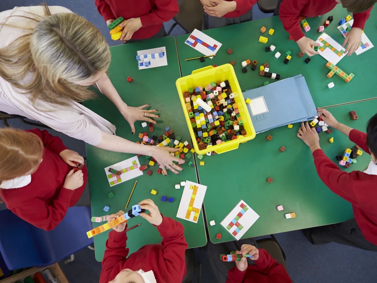 Accueillante joue à un jeu de société avec des enfants de maternelle le matin
