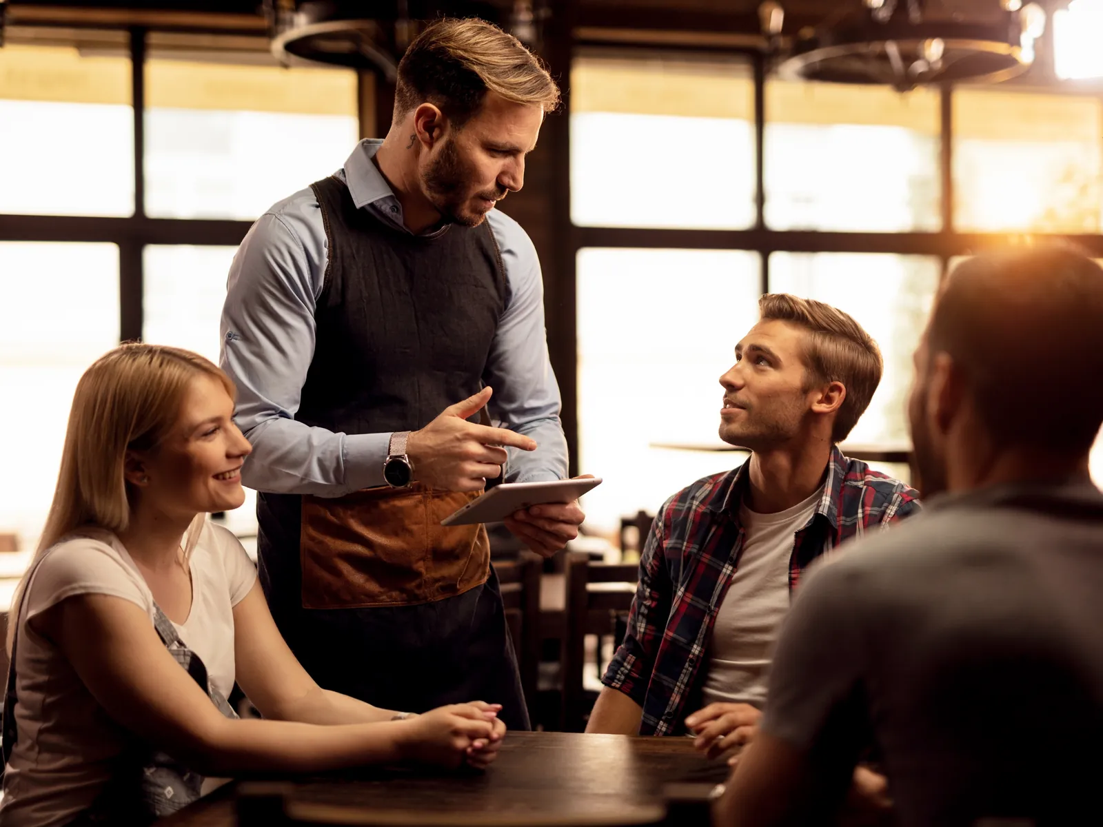 Serveur qui prend une commande en terrasse pleine