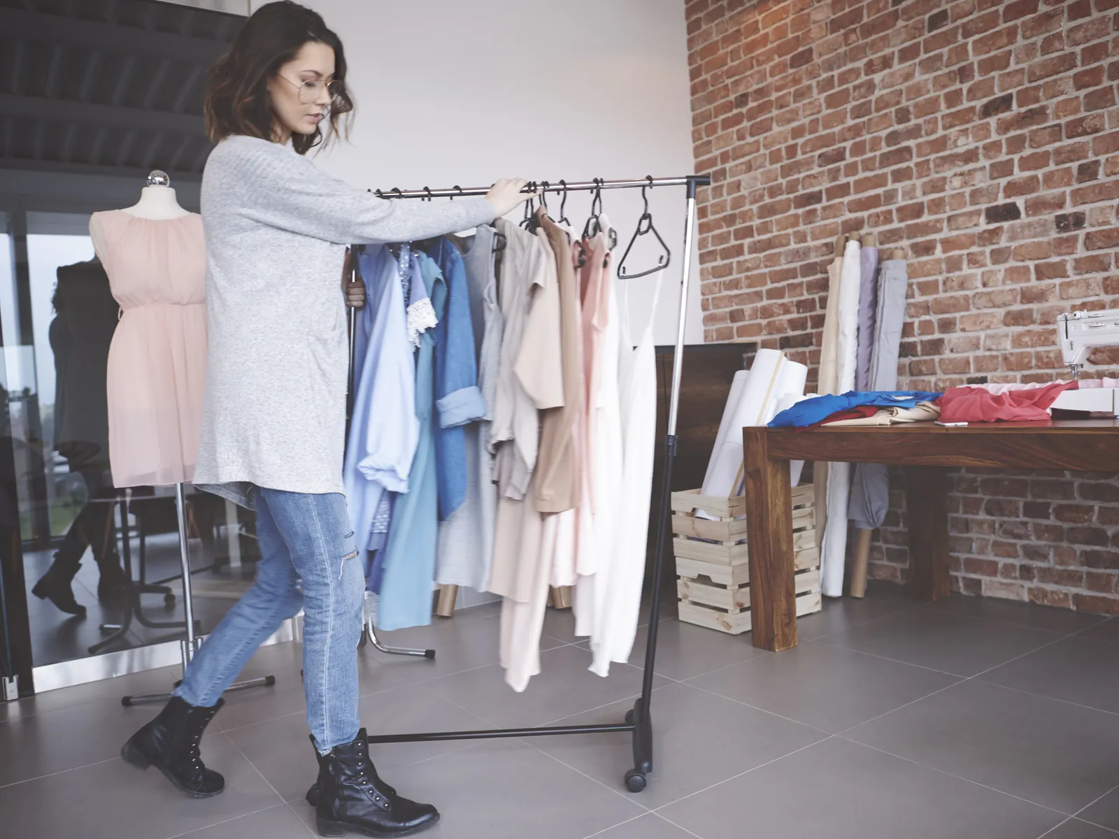 Medewerker brengt een stapel lege kleerhangers naar de achterwinkel na sluiting