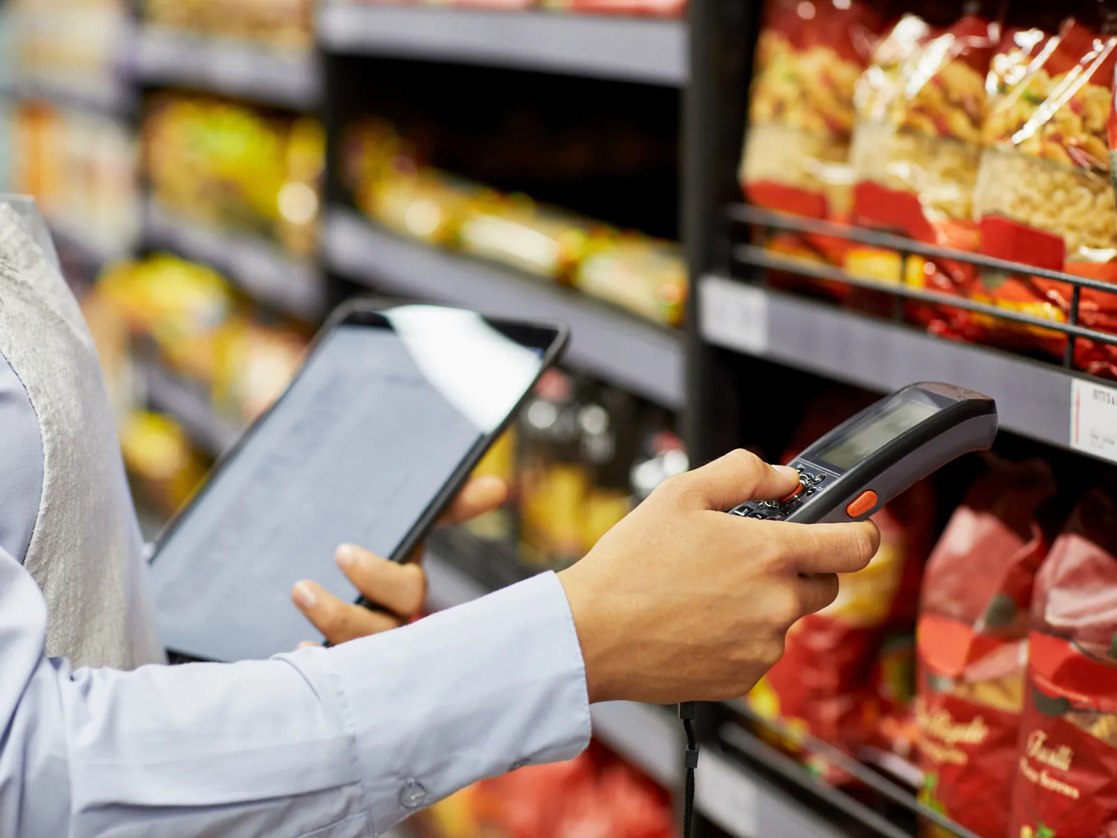 Employé avec un scanner prend des produits en rayon pour une commande à retirer